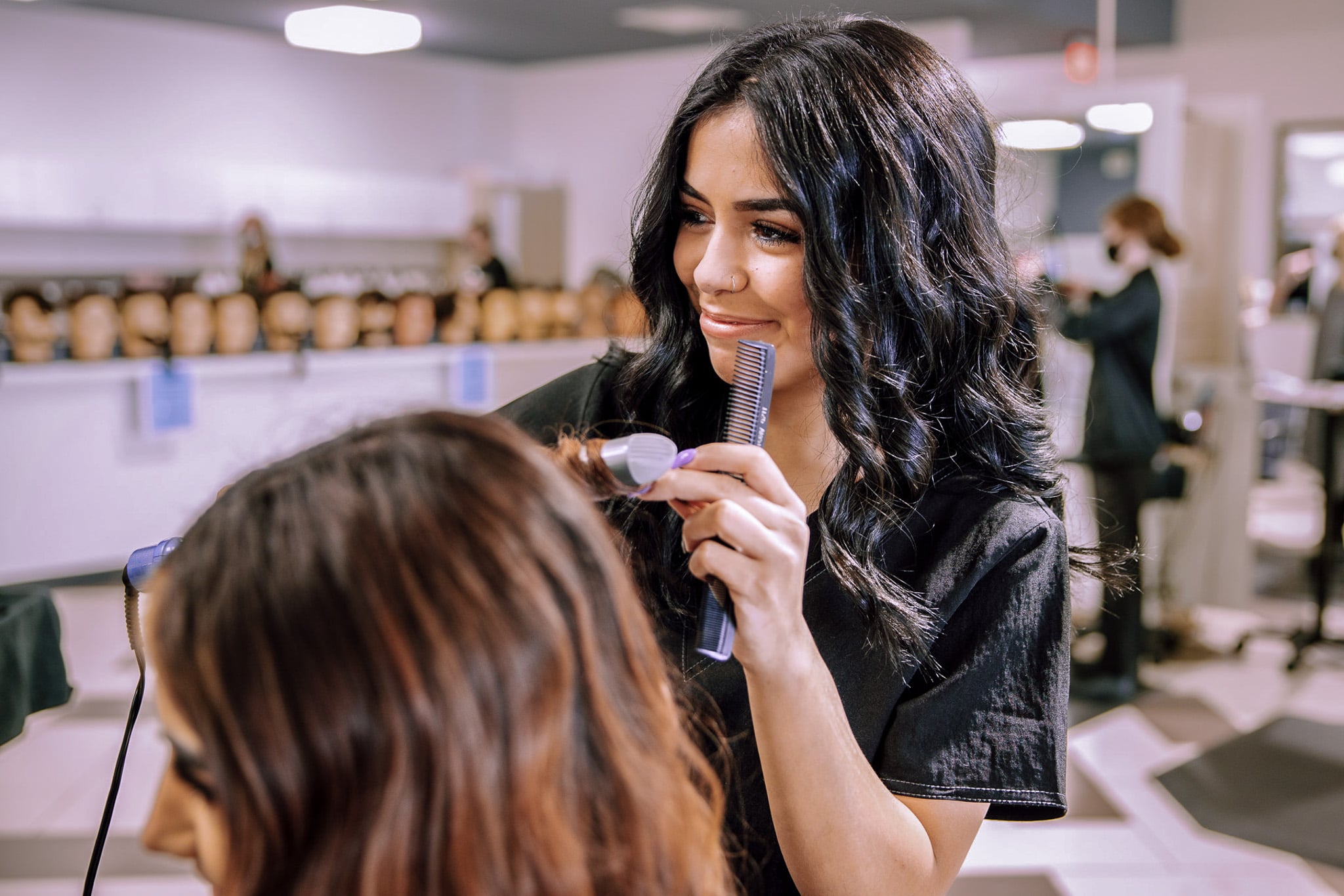 Cosmetology tudent curling hair.