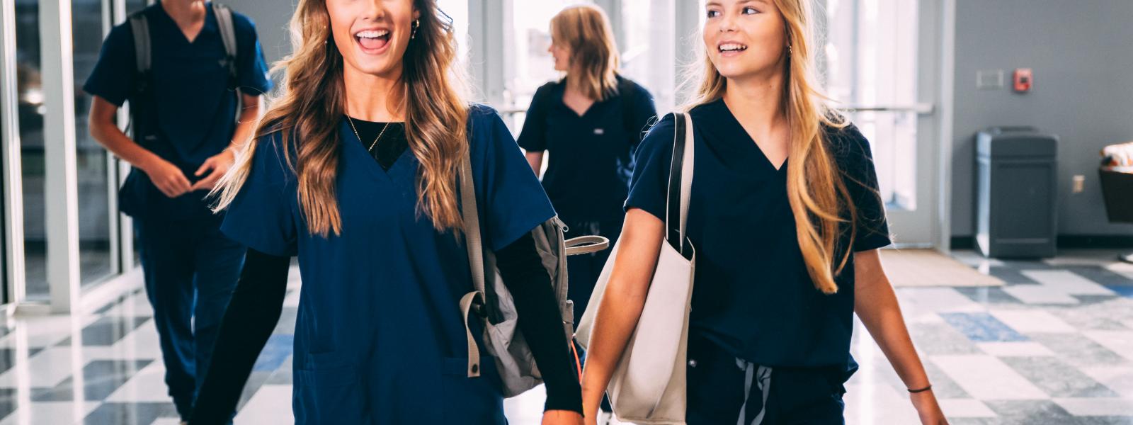 health careers students in scrubs heading to class