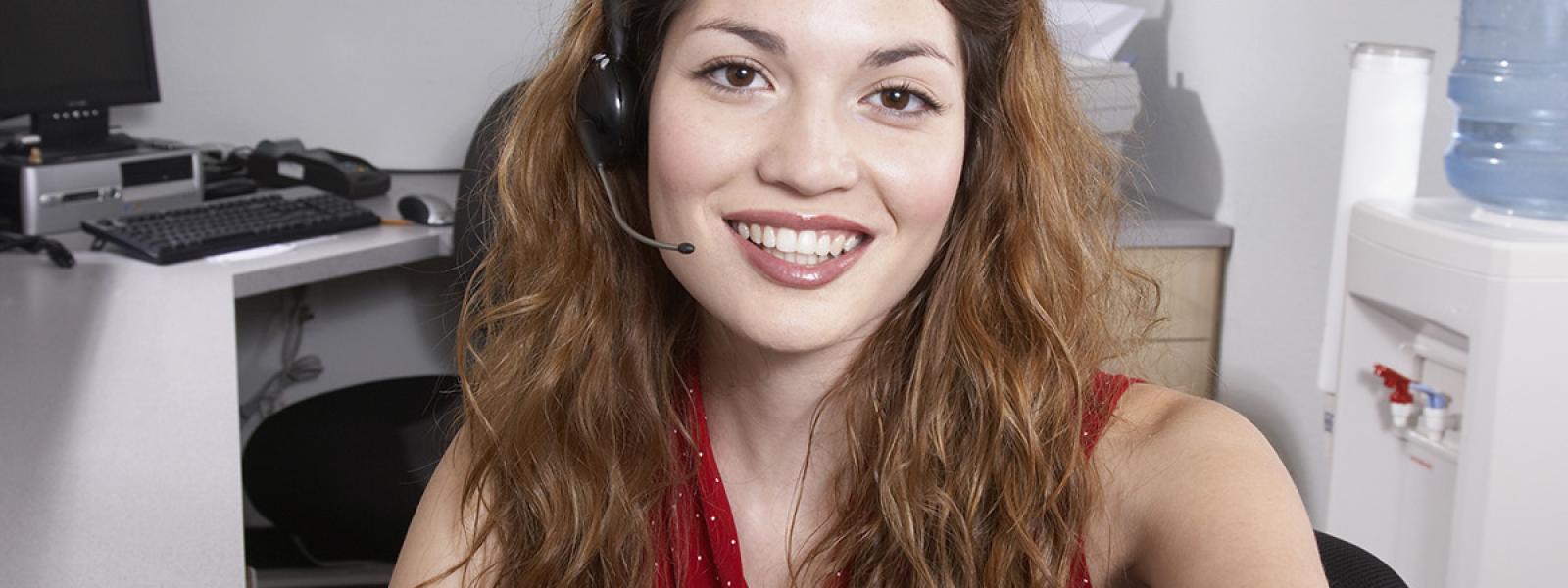 medical office assistant student poses for camera while wearing a headset