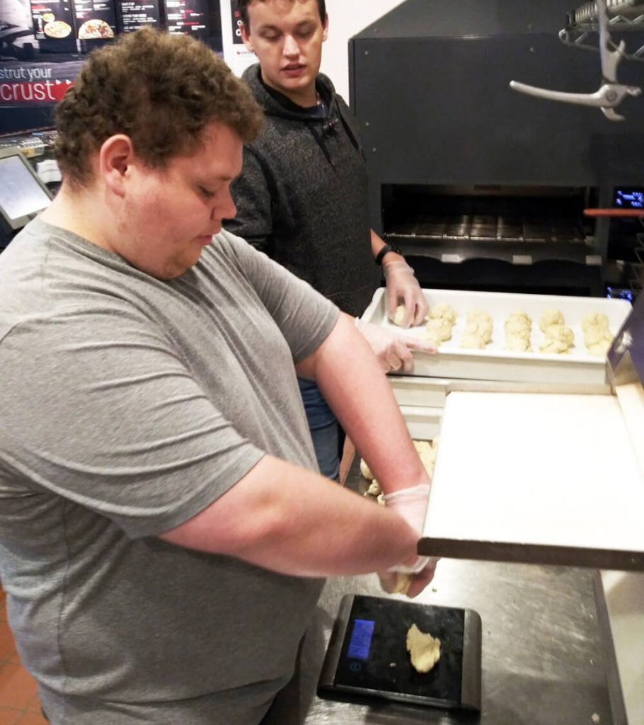 CV Tech student weighs pizza dough at Pie Five restaurant